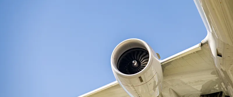 Airliner engine and wing against a blue sky