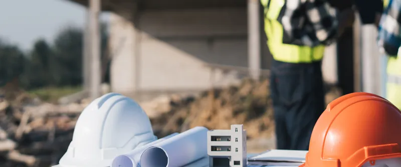 Hard hats and building plans on a construction site